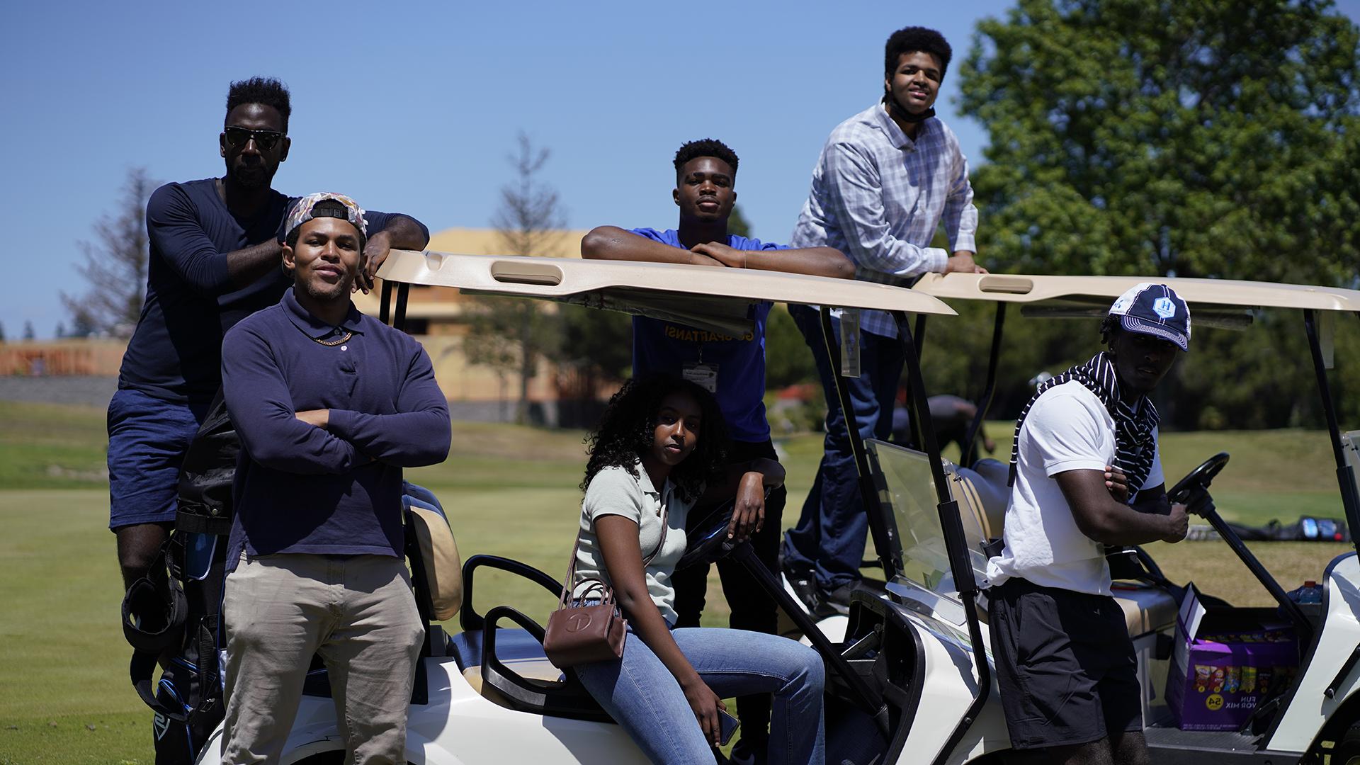 学生们骑着高尔夫球车.